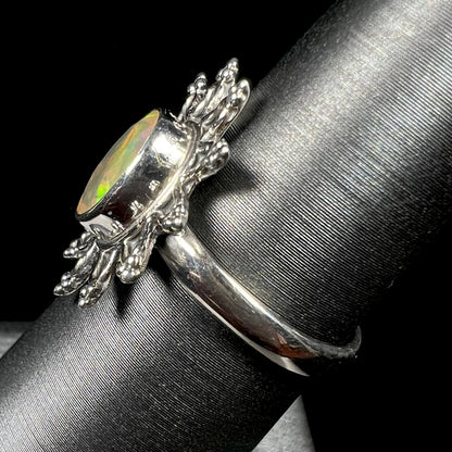 A sterling silver sunburst-style ring mounted with a faceted oval cut Ethiopian fire opal.