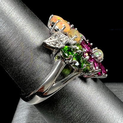 A ladies' gemstone flower design cluster ring set with Ethiopian fire opals, chrome diopsides, rhodolite garnets, and white topaz stones.