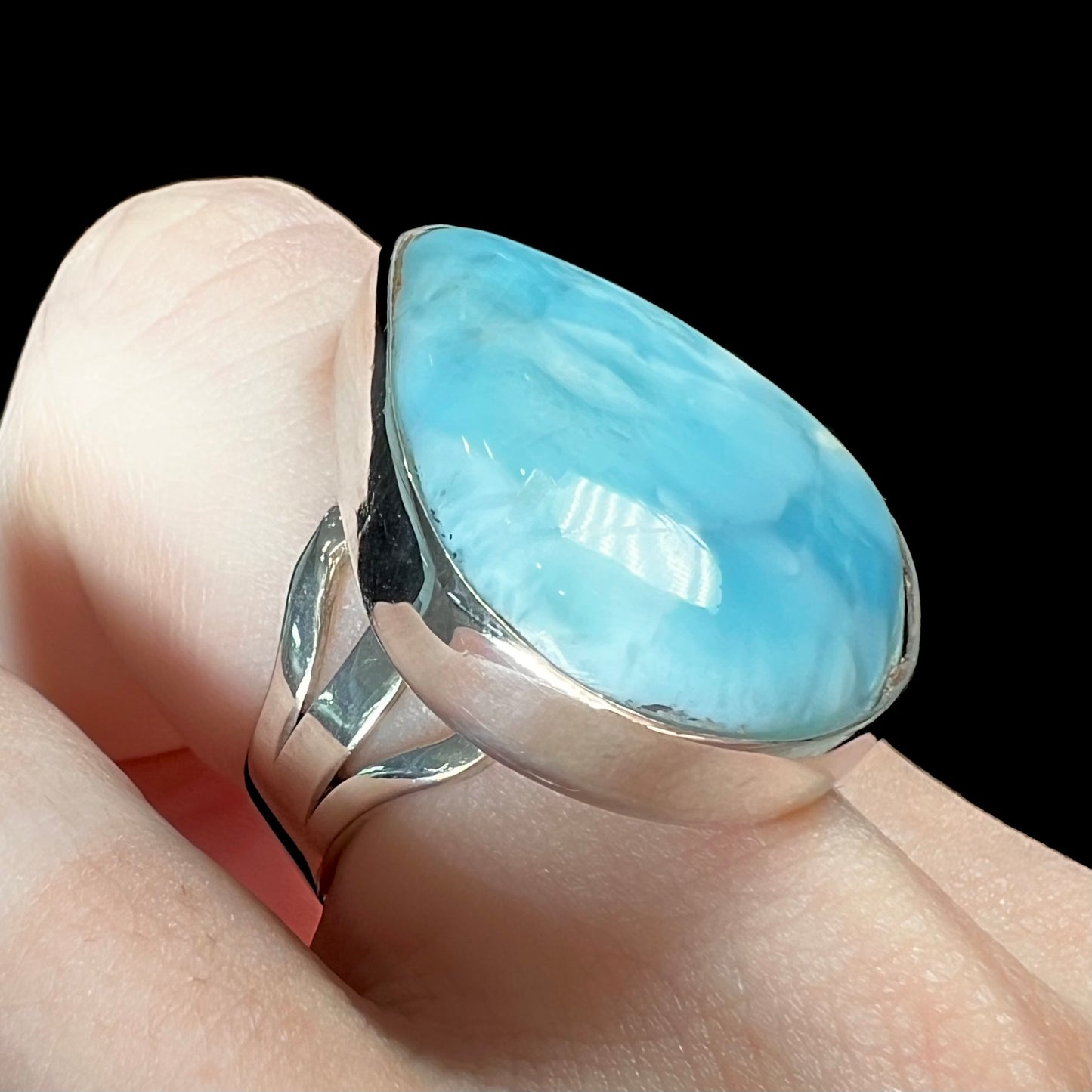 A ladies' large, pear shaped larimar solitaire ring in sterling silver.  The larimar stone measures an inch long.