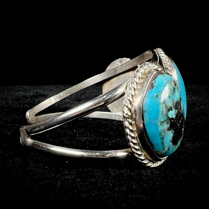 A ladies' three stone silver cuff bracelet accented with rope bezels and set with Morenci turquoise.