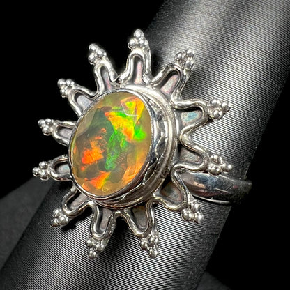 A sterling silver sunburst-style ring mounted with a faceted oval cut Ethiopian fire opal.