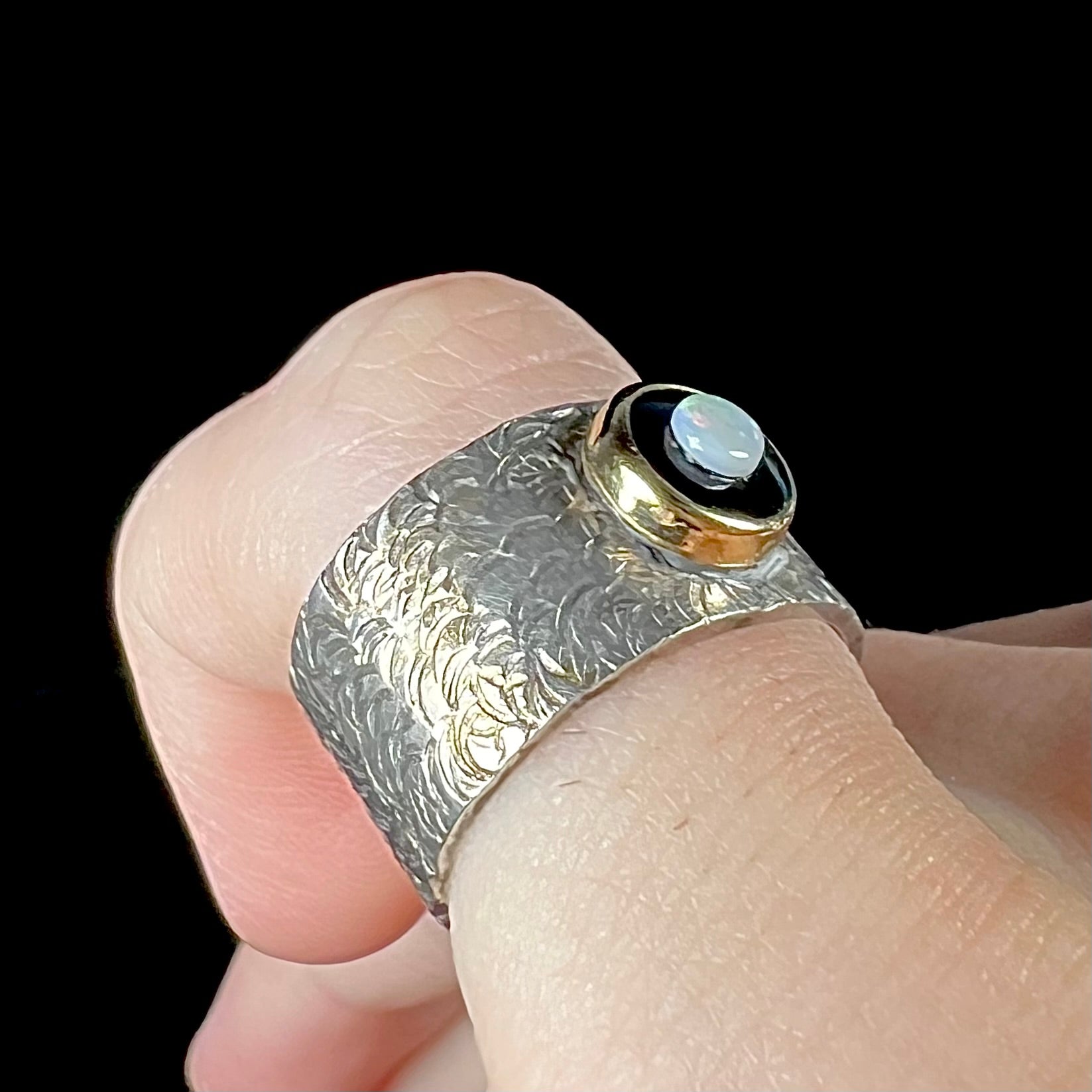 An opal and black onyx inlay ring in a sterling silver cigar-style pinkie ring.