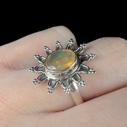 A sterling silver sunburst-style ring mounted with a faceted oval cut Ethiopian fire opal.