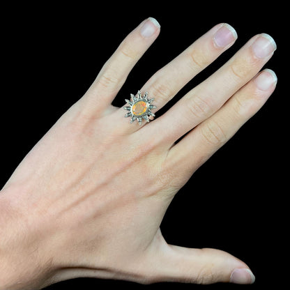 A sterling silver sunburst-style ring mounted with a faceted oval cut Ethiopian fire opal.