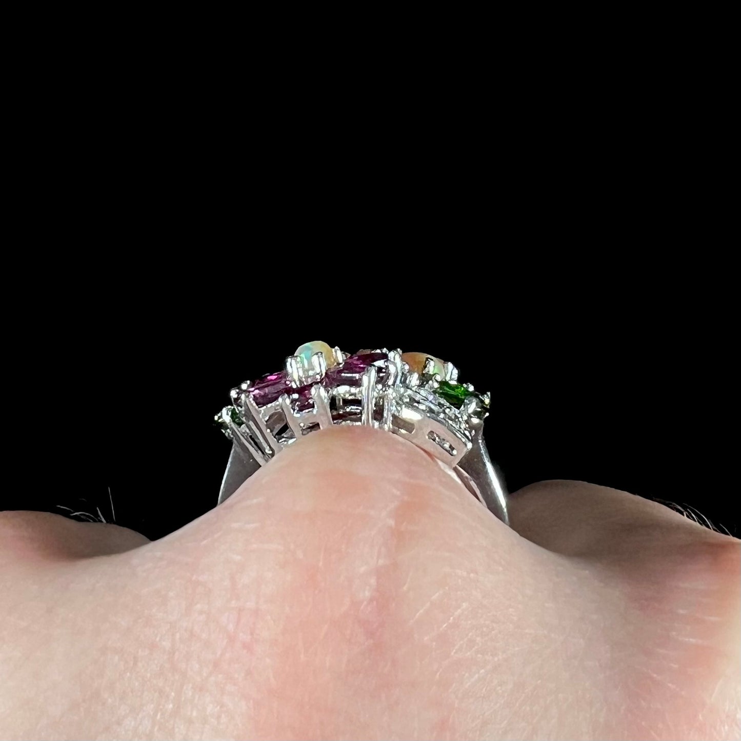 A ladies' gemstone flower design cluster ring set with Ethiopian fire opals, chrome diopsides, rhodolite garnets, and white topaz stones.