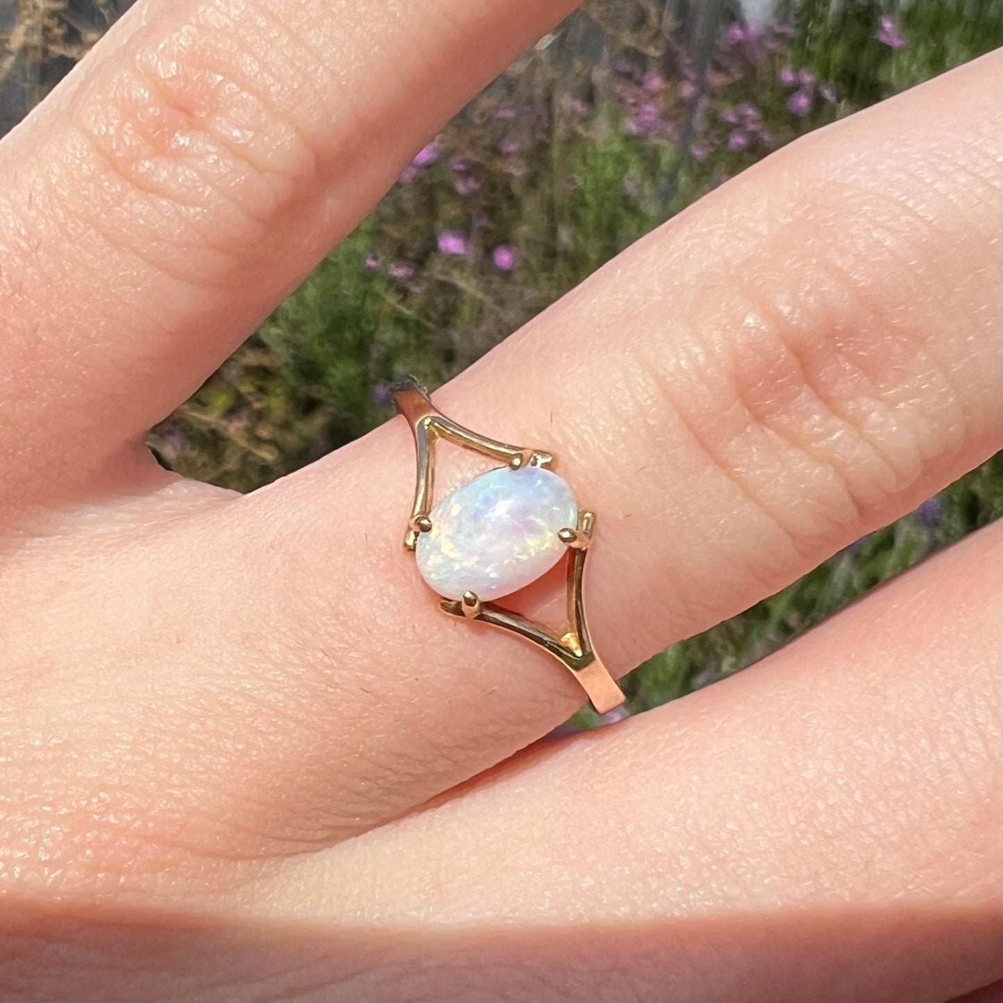 A ladies' simple opal solitaire ring.  The ring is yellow gold with a split shank.