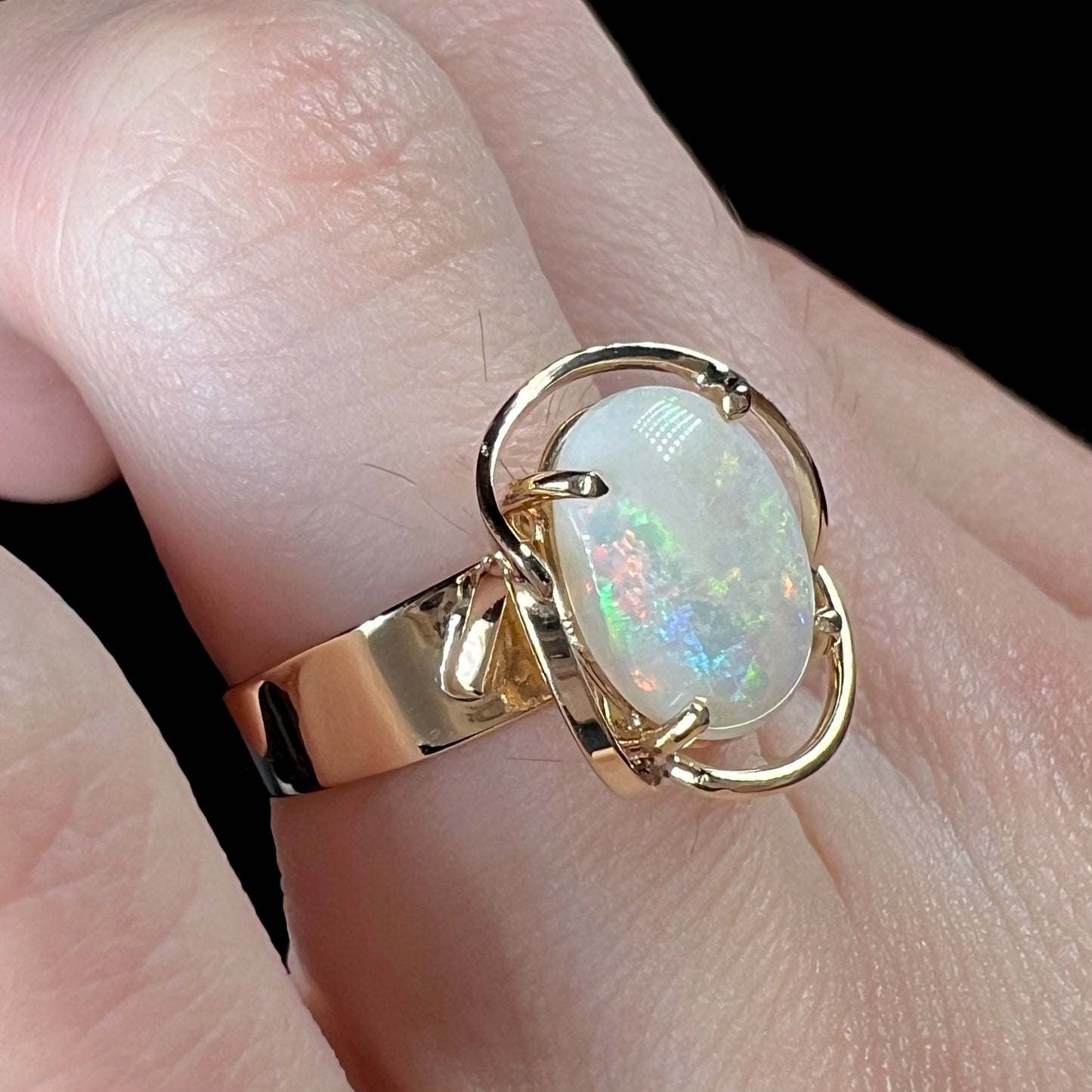 A yellow gold solitaire ring mounted with an oval cut Australian white opal.