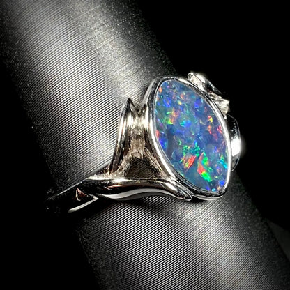 A sterling silver ring mounted with a marquise cut black opal doublet.  The opal has red fire.