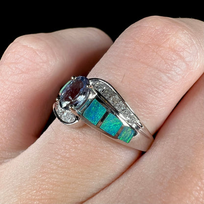 A ladies' white gold tanzanite ring with black opal doublet and diamond accents.