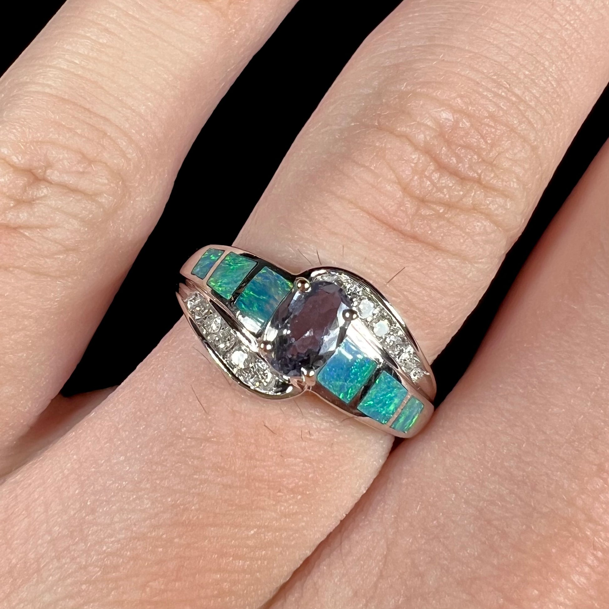 A ladies' white gold tanzanite ring with black opal doublet and diamond accents.