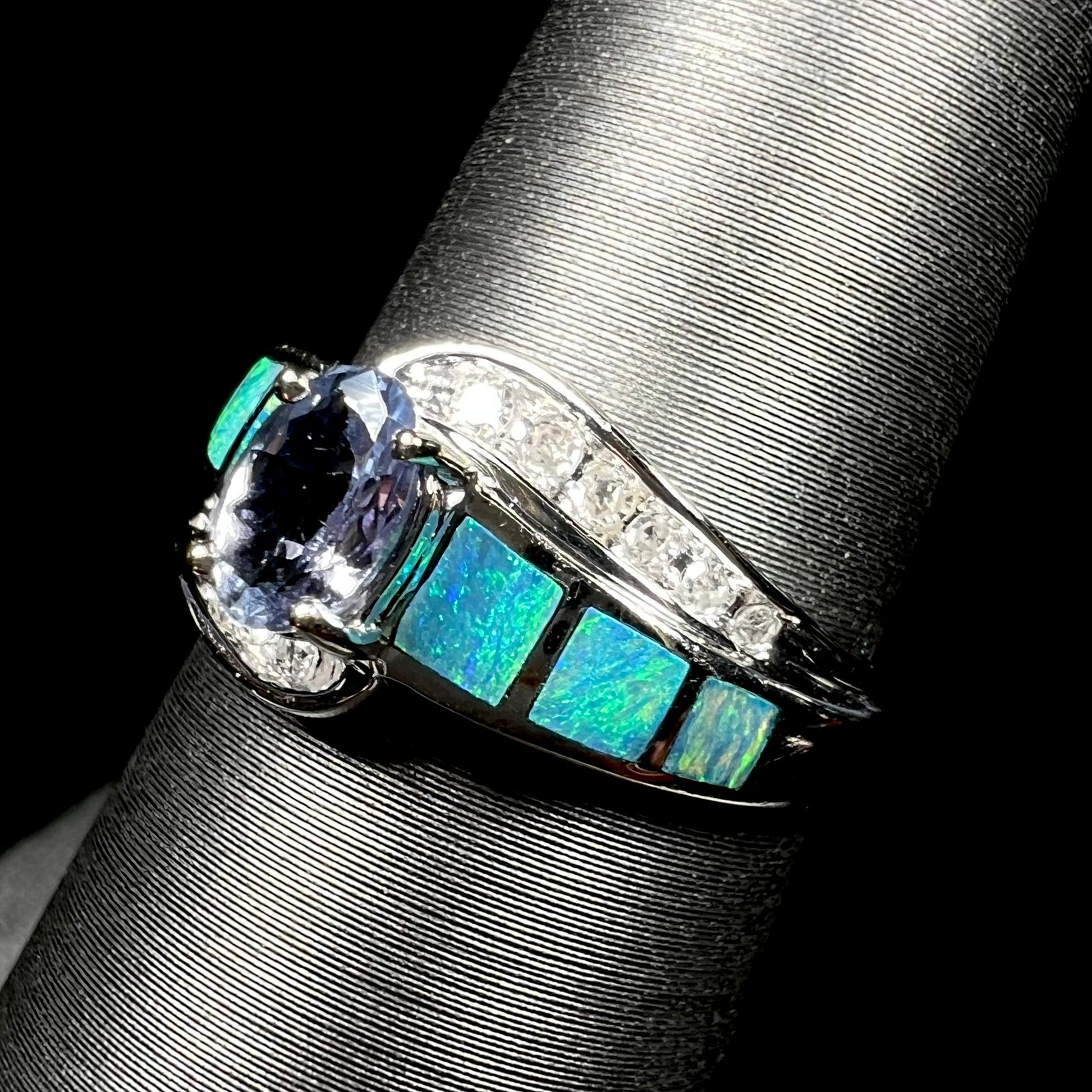 A ladies' white gold tanzanite ring with black opal doublet and diamond accents.