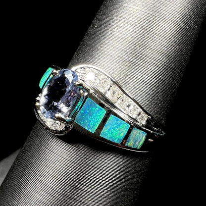 A ladies' white gold tanzanite ring with black opal doublet and diamond accents.