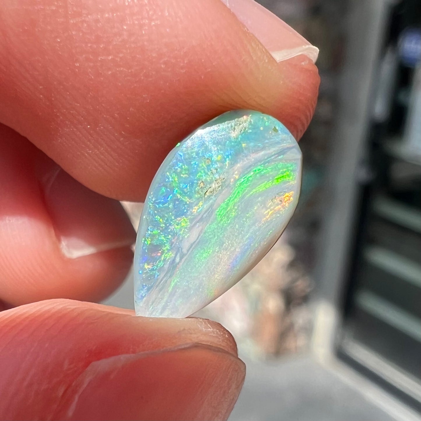 A loose, pear shaped Australian opal stone.  The opal shows green and blue colors.