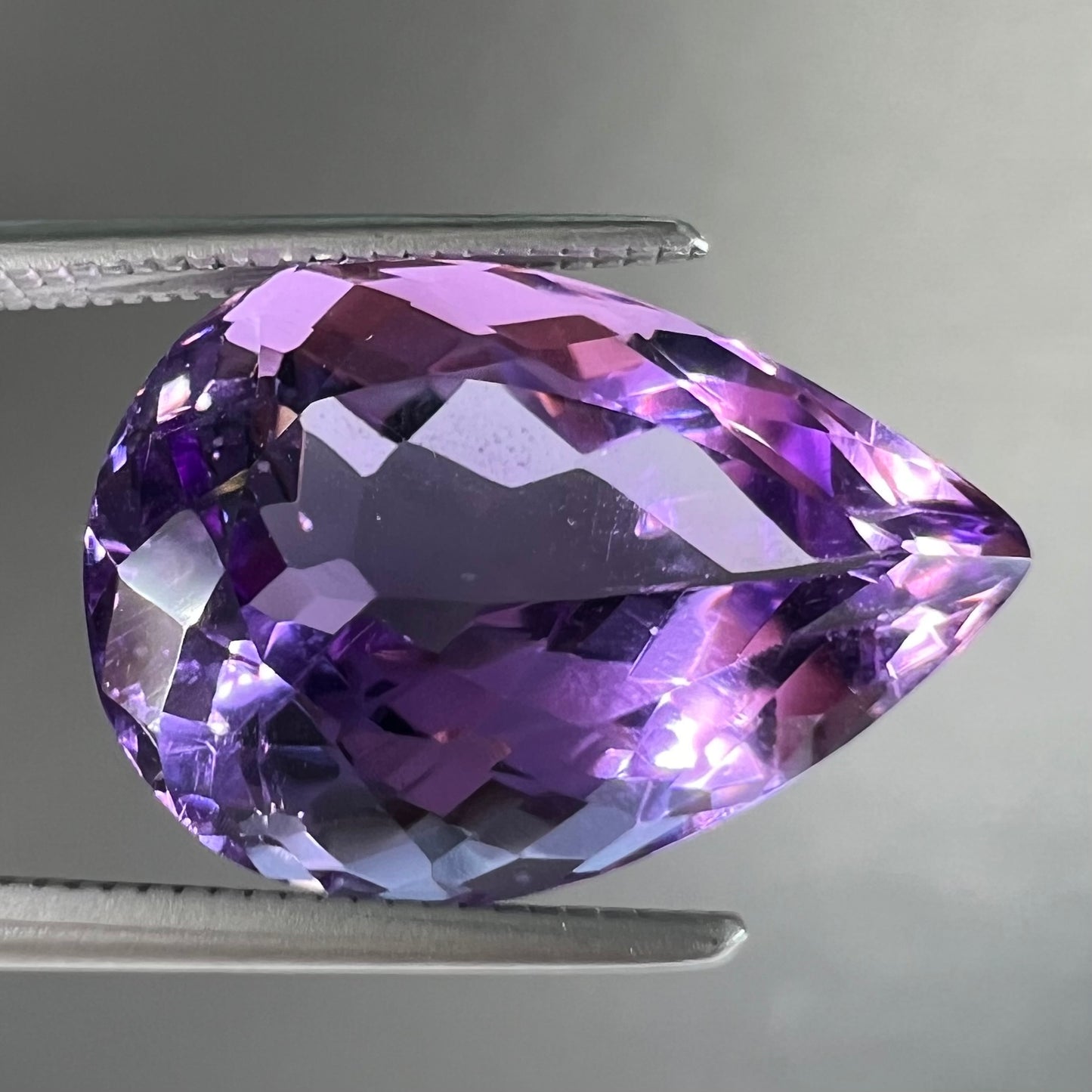 A loose, pear shaped amethyst gemstone.  The stone is a medium purple color.