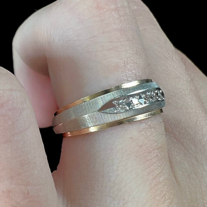 A unisex, two-tone white and yellow gold diamond wedding band.  The white gold is textured.