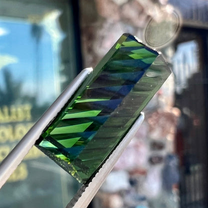 A loose, rectangular laser cut green tourmaline gemstone.