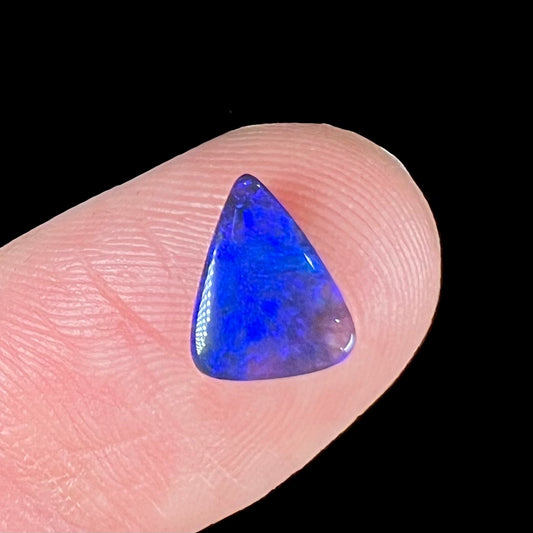 A loose, triangular cut black semi-crystal stone.