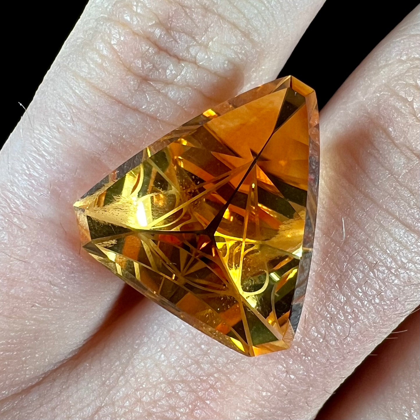 A loose, triangular fantasy cut yellow citrine stone cut by Arthur Lee Anderson.