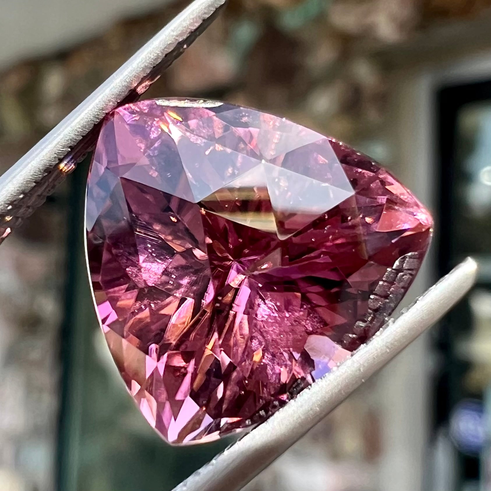 A loose, checkerboard trillion cut purple tourmaline gemstone.