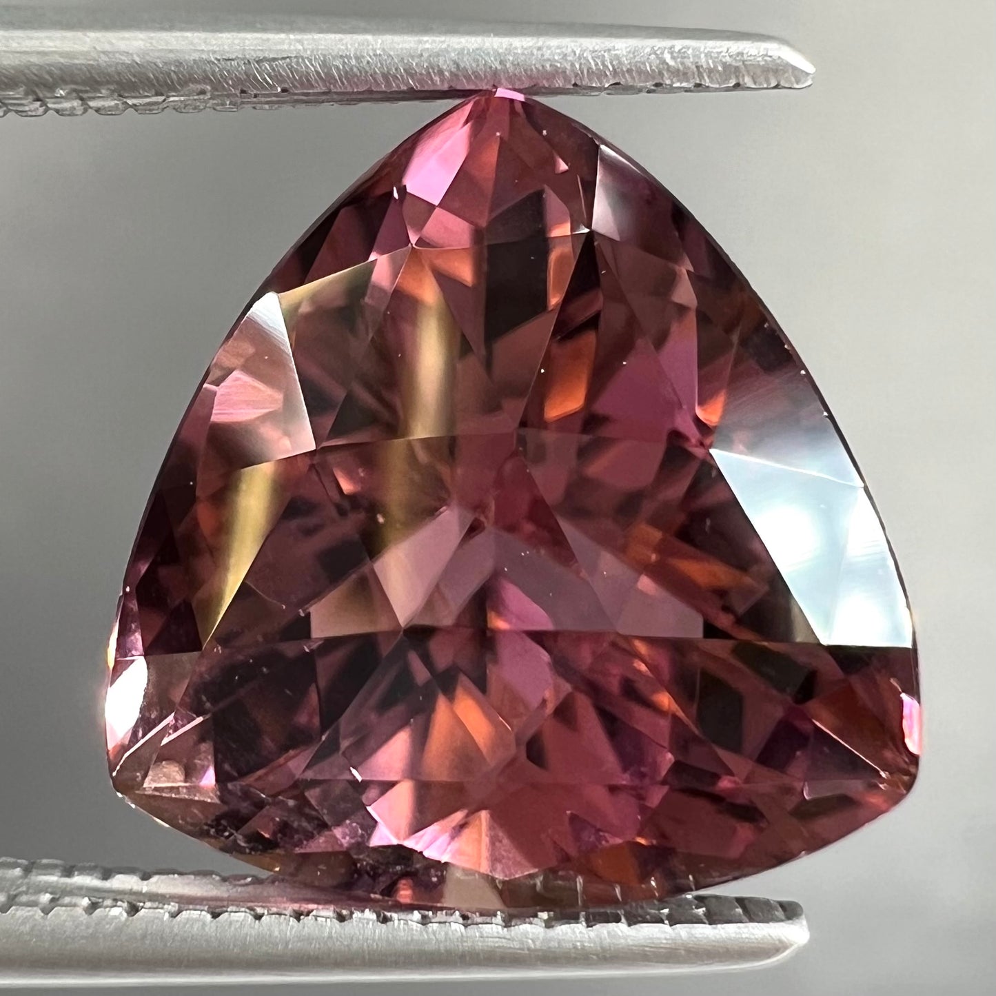 A loose, checkerboard trillion cut purple tourmaline gemstone.