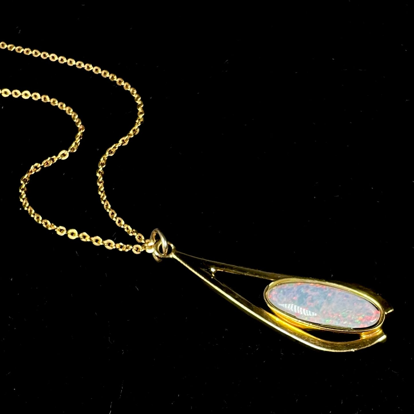 A yellow gold plated necklace set with an oval cut opal triplet.