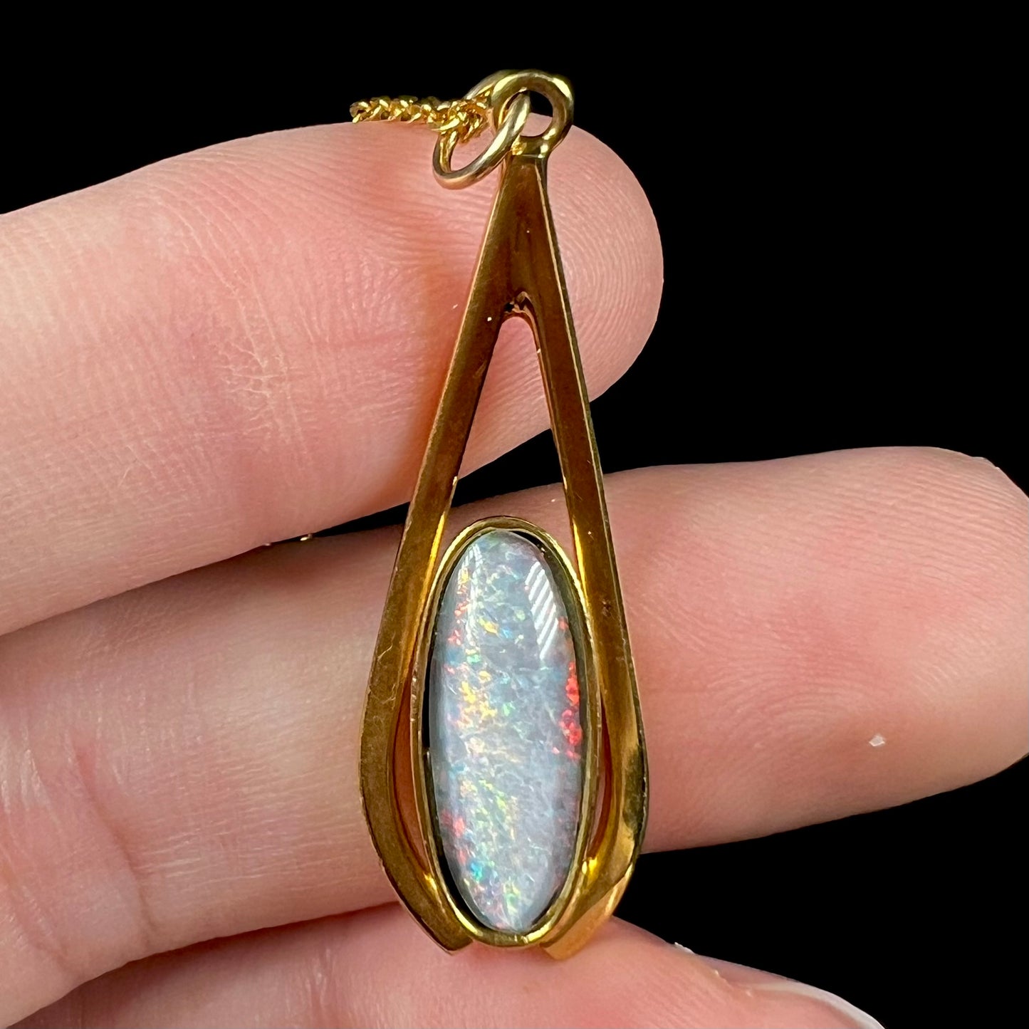 A yellow gold plated necklace set with an oval cut opal triplet.