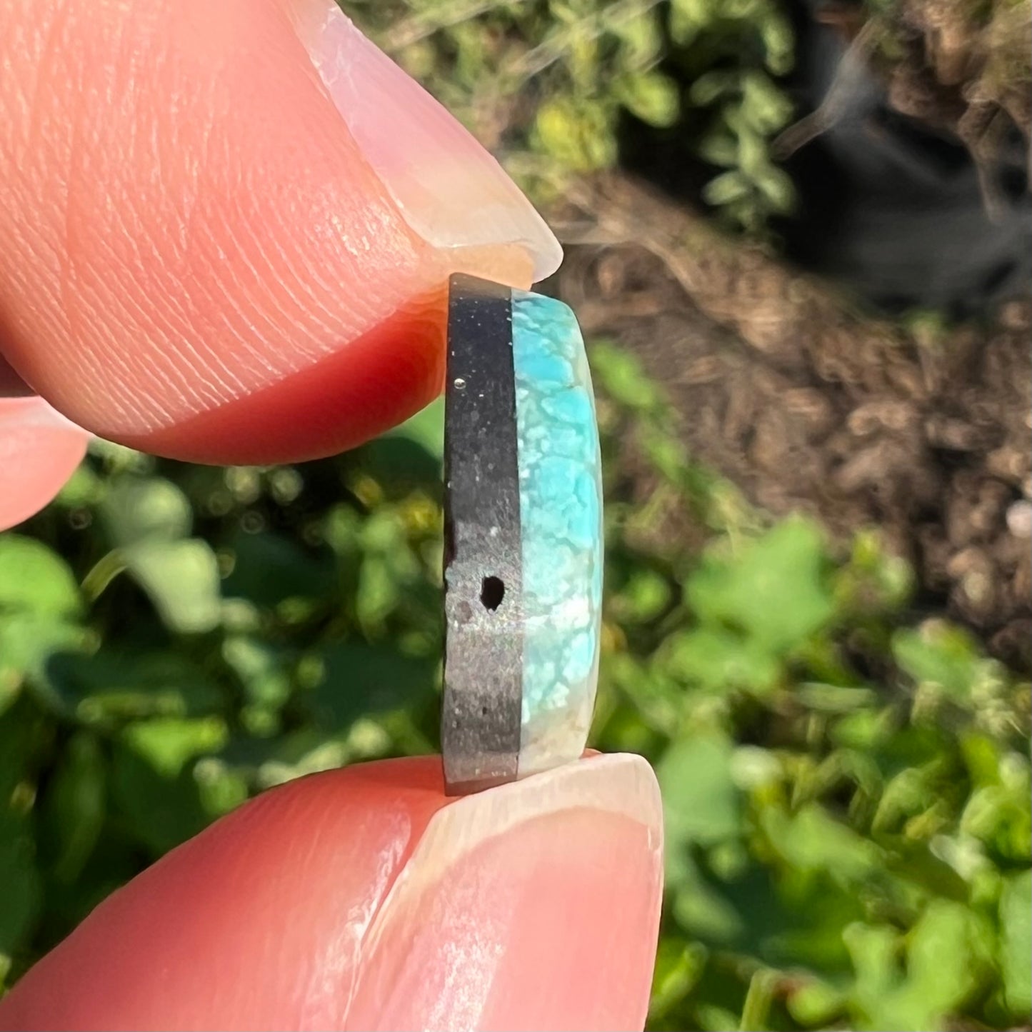 A loose, freeform pear shaped cabochon cut Valley Blue turquoise stone from Lander County, Nevada.  The stone is blue and green with quartz inclusions.