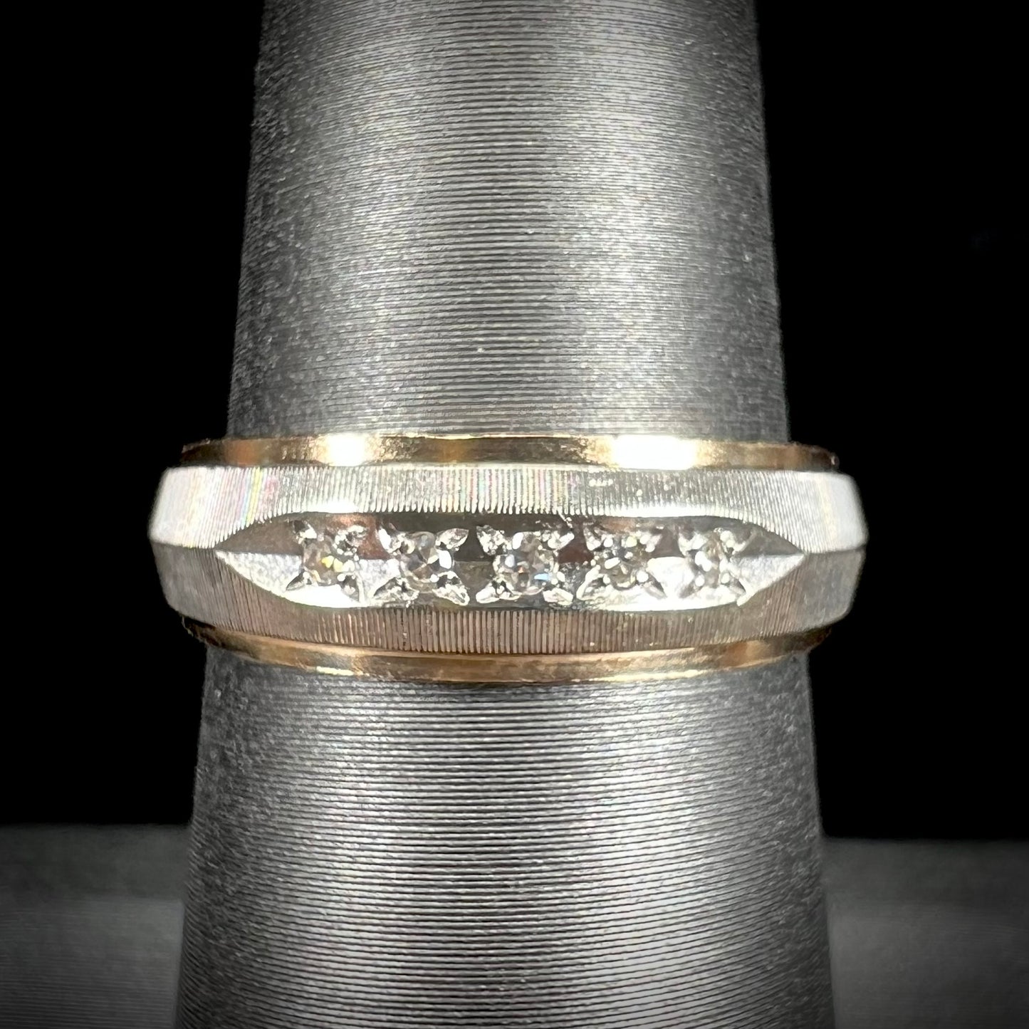 A unisex, two-tone white and yellow gold diamond wedding band.  The white gold is textured.