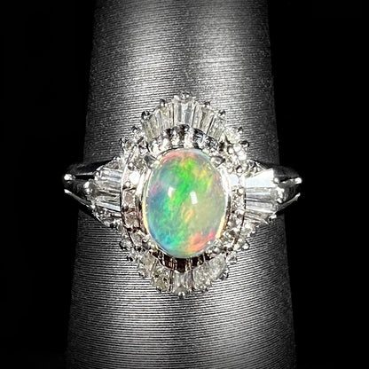 A platinum ring mounted with a Mexican fire opal and baguette cut diamond accents.