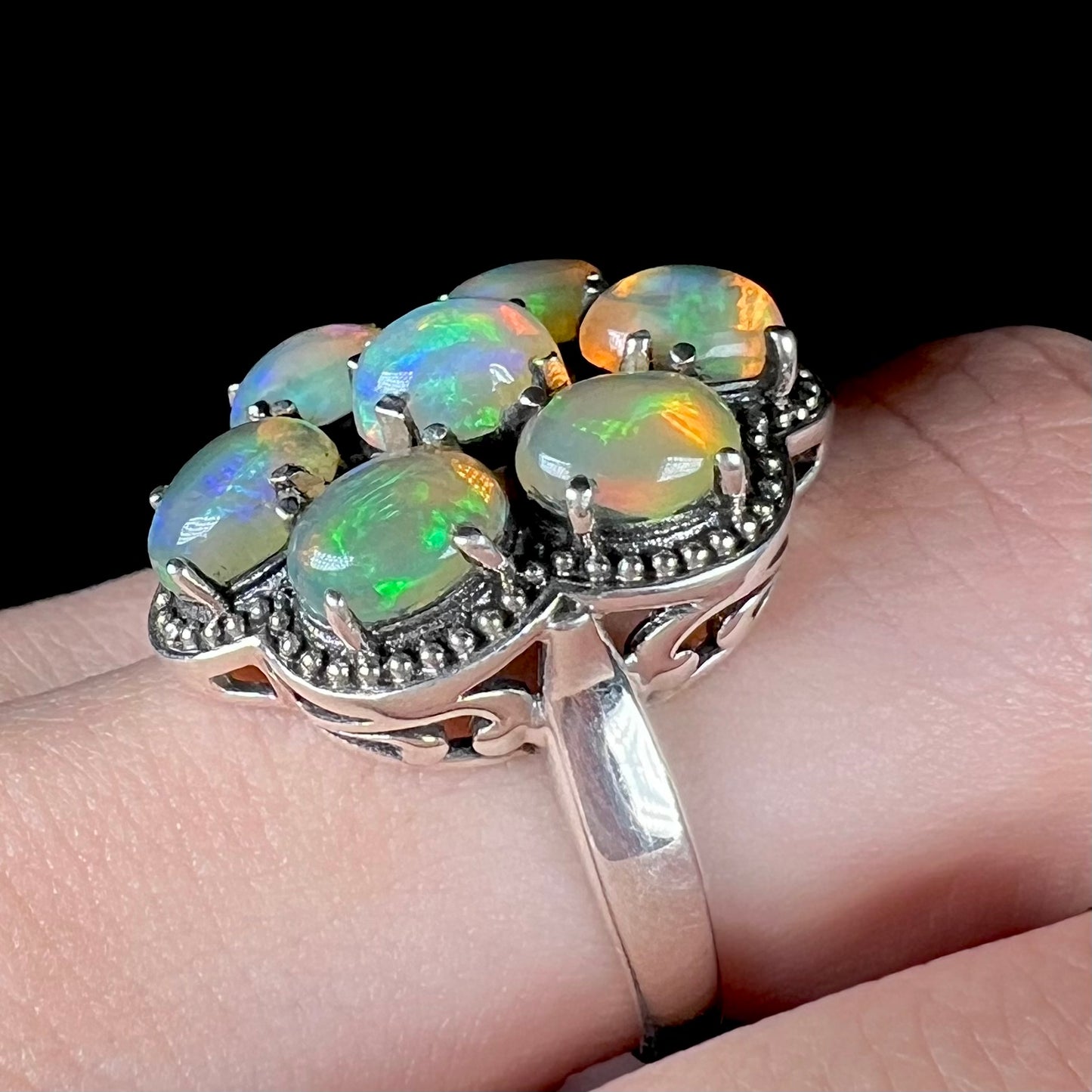 A sterling silver cluster ring prong-set with seven green Ethiopian fire opals.