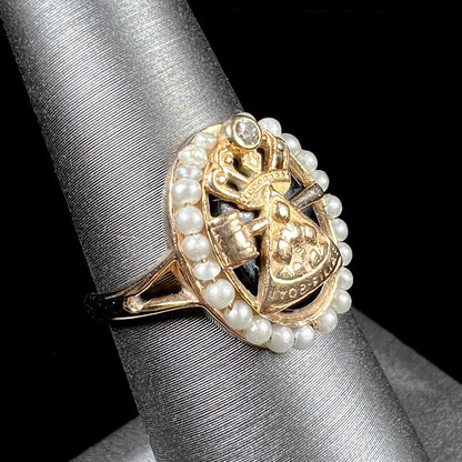 A ladies' Job's Daughters youth organization ring cast in 14 karat gold, set with a diamond and string of pearls.