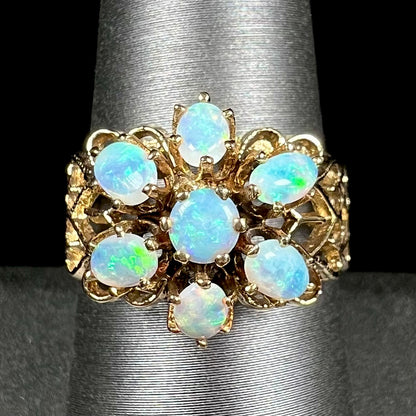 A vintage, 1950's style opal cluster ring cast in yellow gold with a heart shaped filigree design.