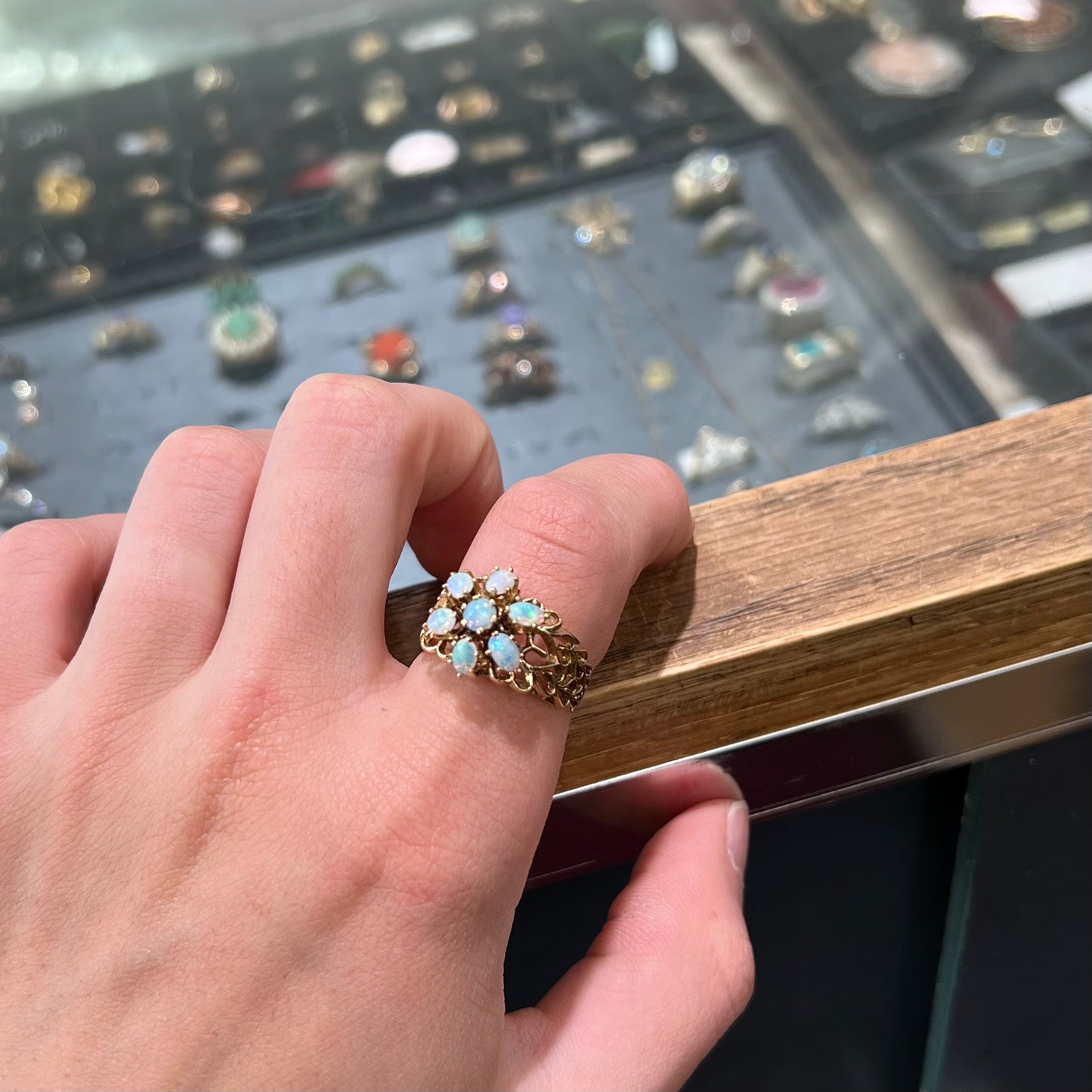 A vintage, 1950's style opal cluster ring cast in yellow gold with a heart shaped filigree design.