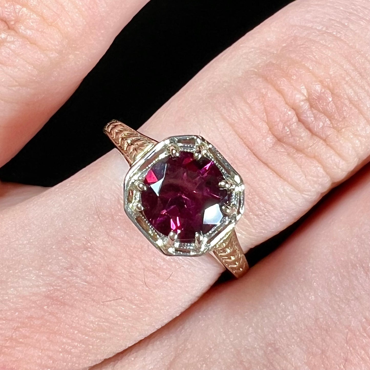 A ladies' yellow gold Art Deco style solitaire ring set with a purple rhodolite garnet gemstone.