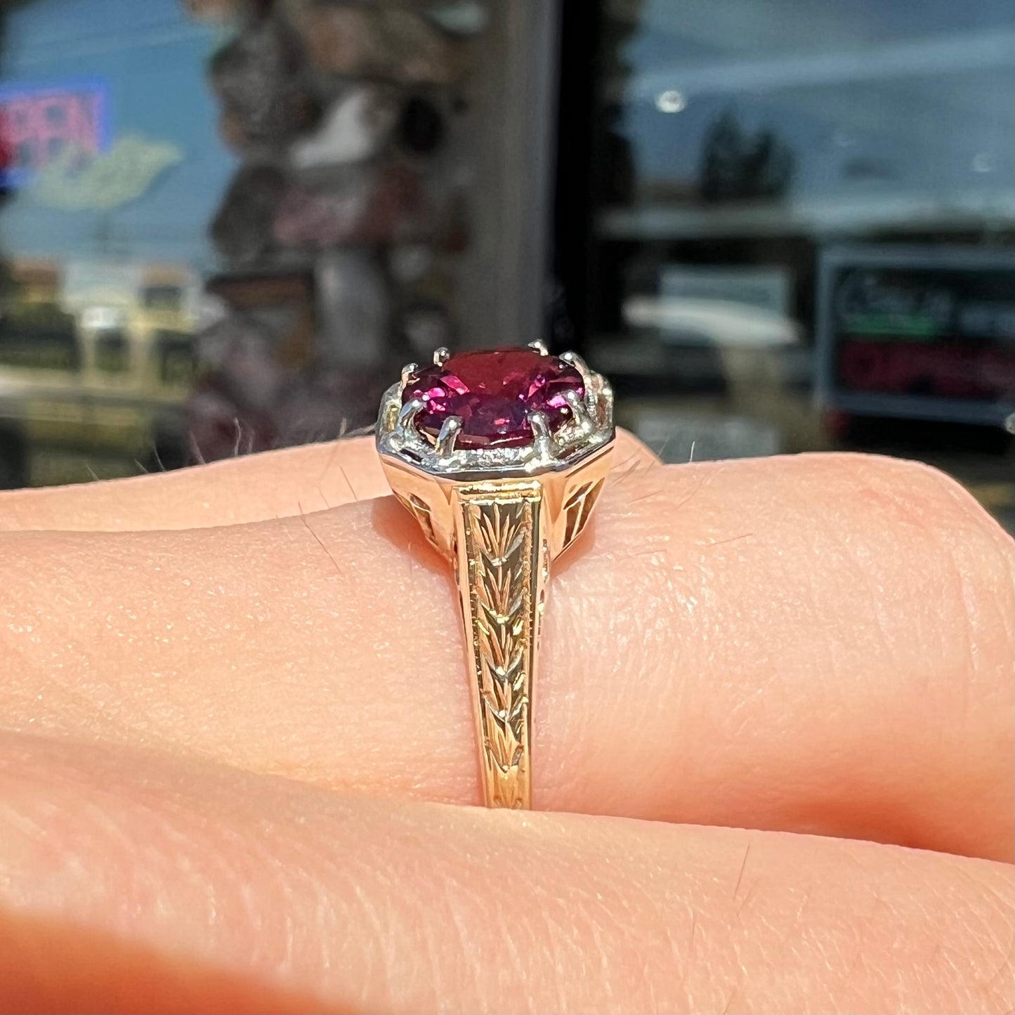 A ladies' yellow gold Art Deco style solitaire ring set with a purple rhodolite garnet gemstone.