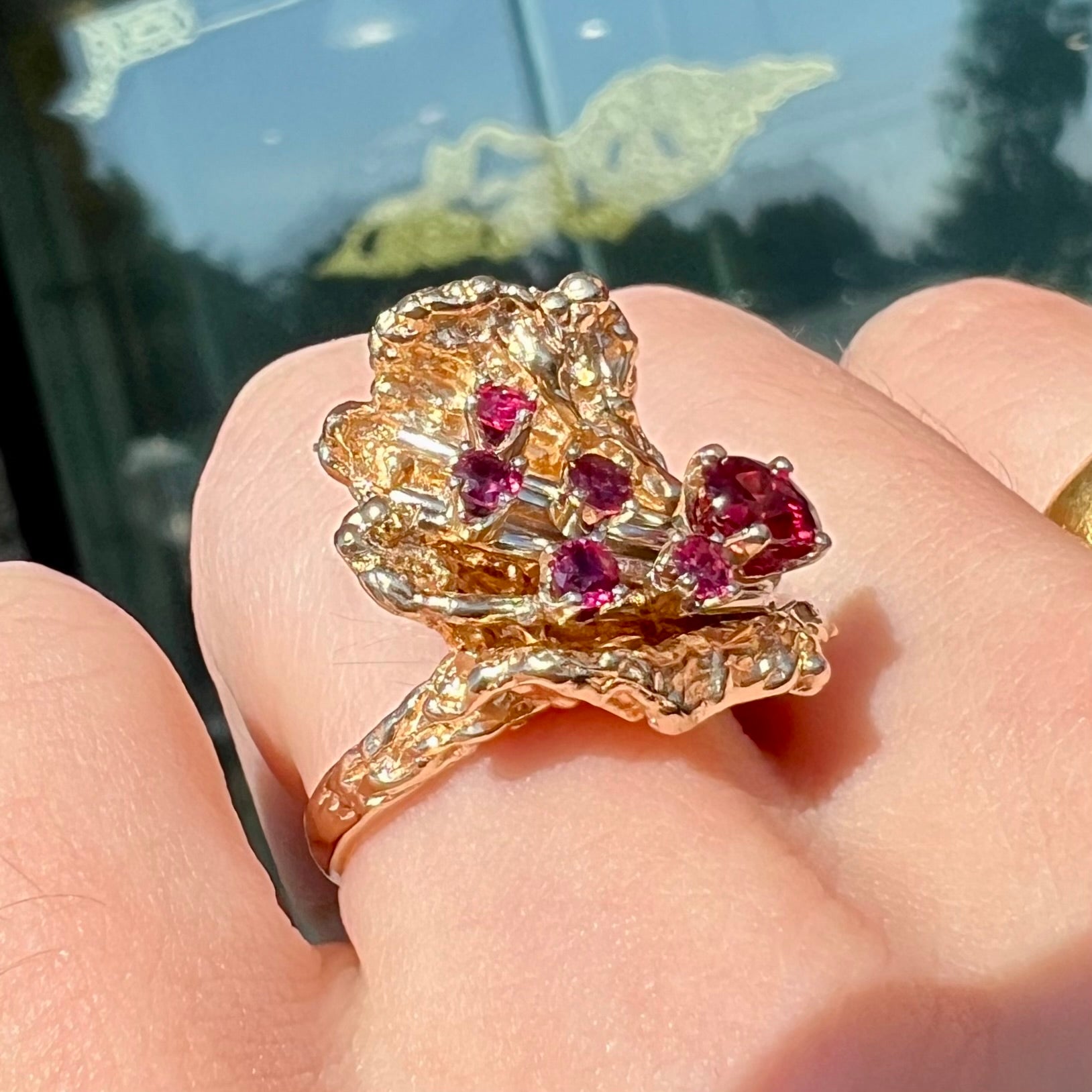 A yellow gold ruby cluster ring from the 1950's.  There is one oval cut ruby and five round cut rubies.