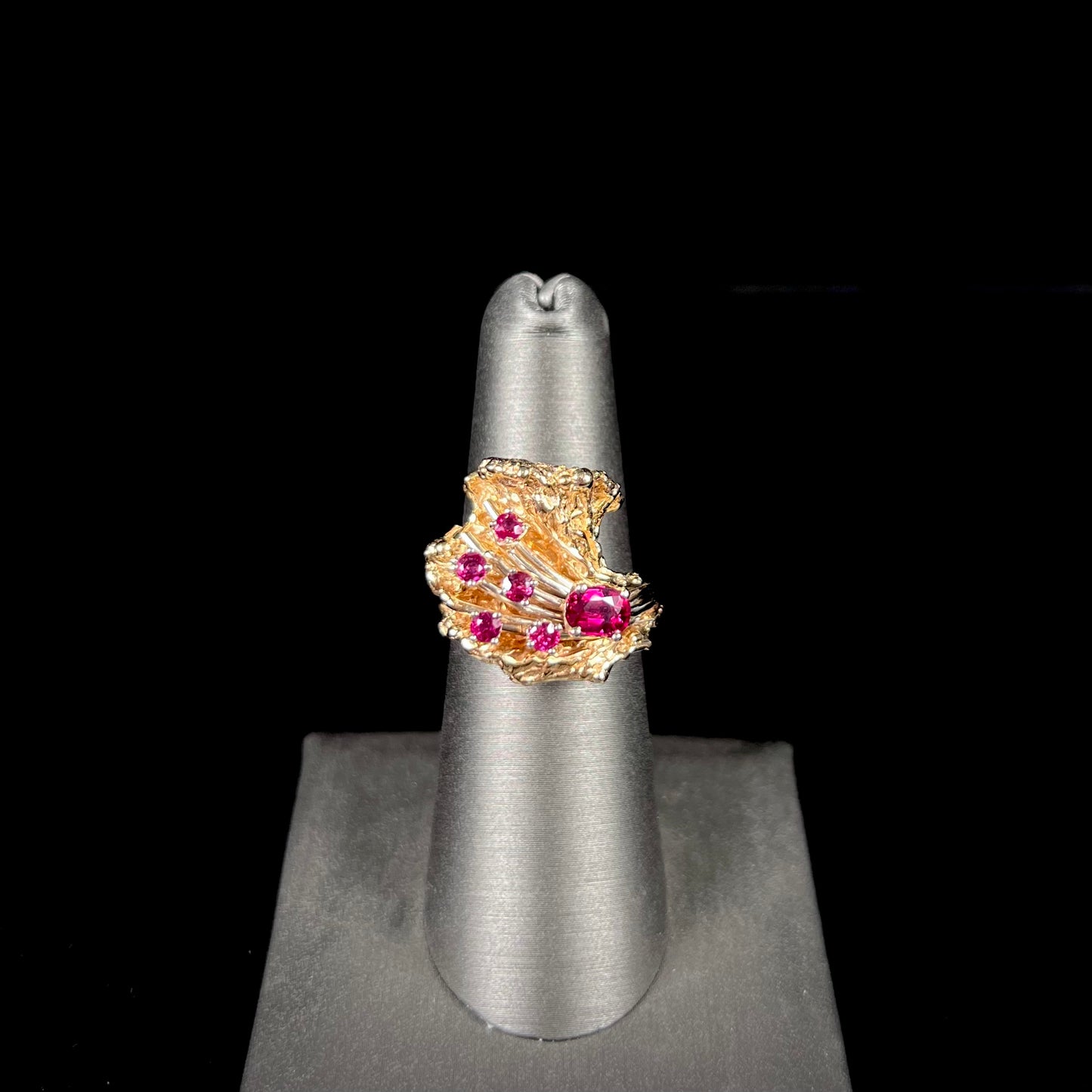 A yellow gold ruby cluster ring from the 1950's.  There is one oval cut ruby and five round cut rubies.