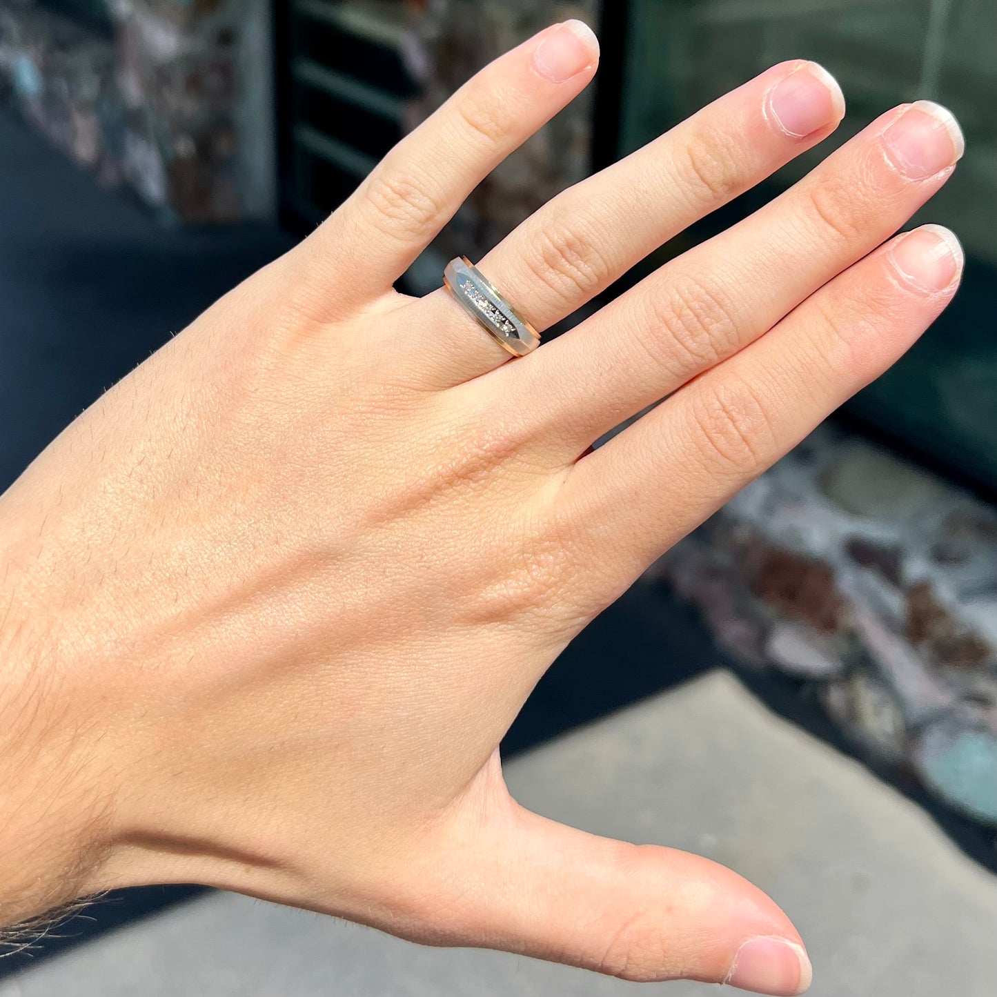 A unisex, two-tone white and yellow gold diamond wedding band.  The white gold is textured.