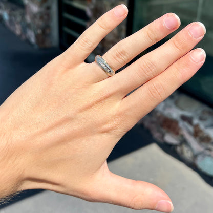 A unisex, two-tone white and yellow gold diamond wedding band.  The white gold is textured.