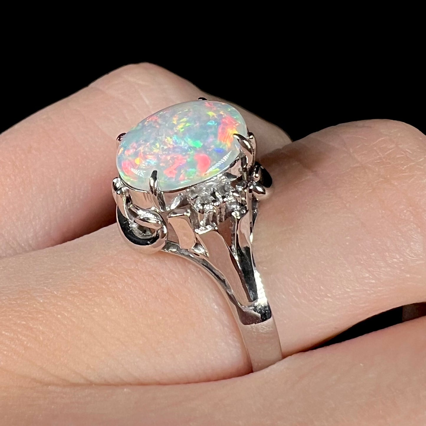 A platinum  and diamond ring prong-set with an Australian opal.  The opal has pink color play.