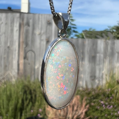 A platinum pendant mounted with an oval cut Australian white opal.