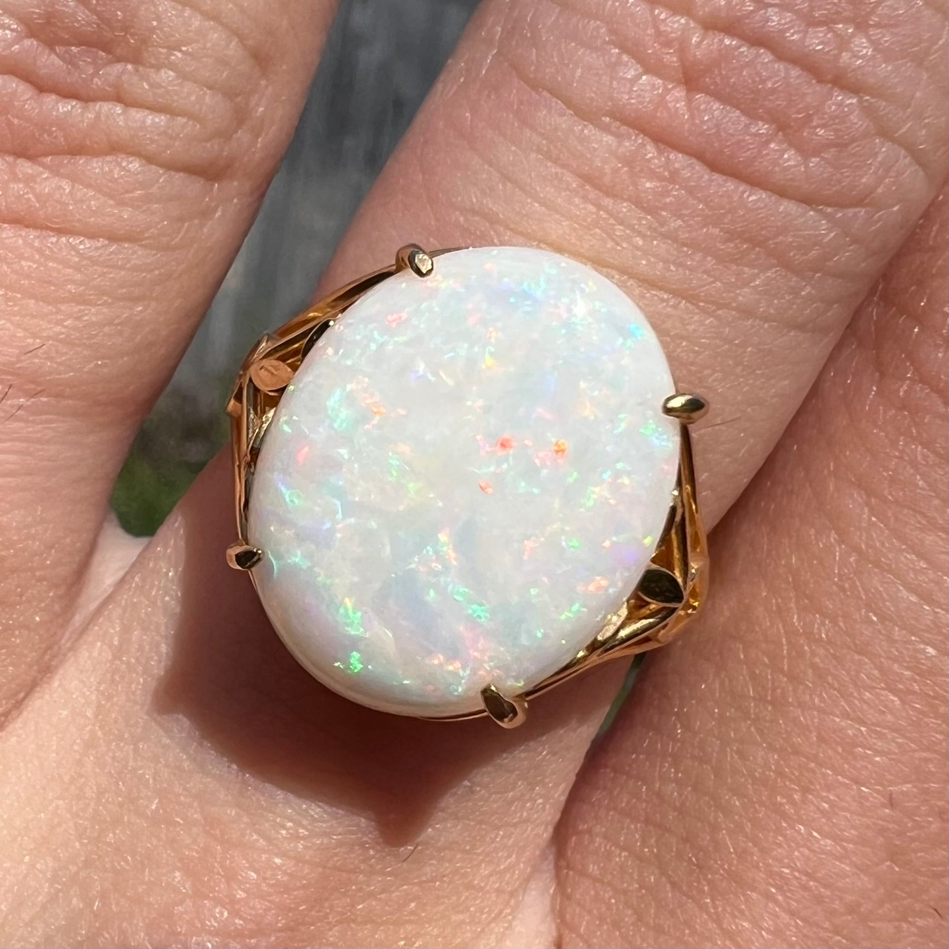 A yellow gold solitaire cocktail ring mounted with a natural white opal from Coober Pedy, Australia.