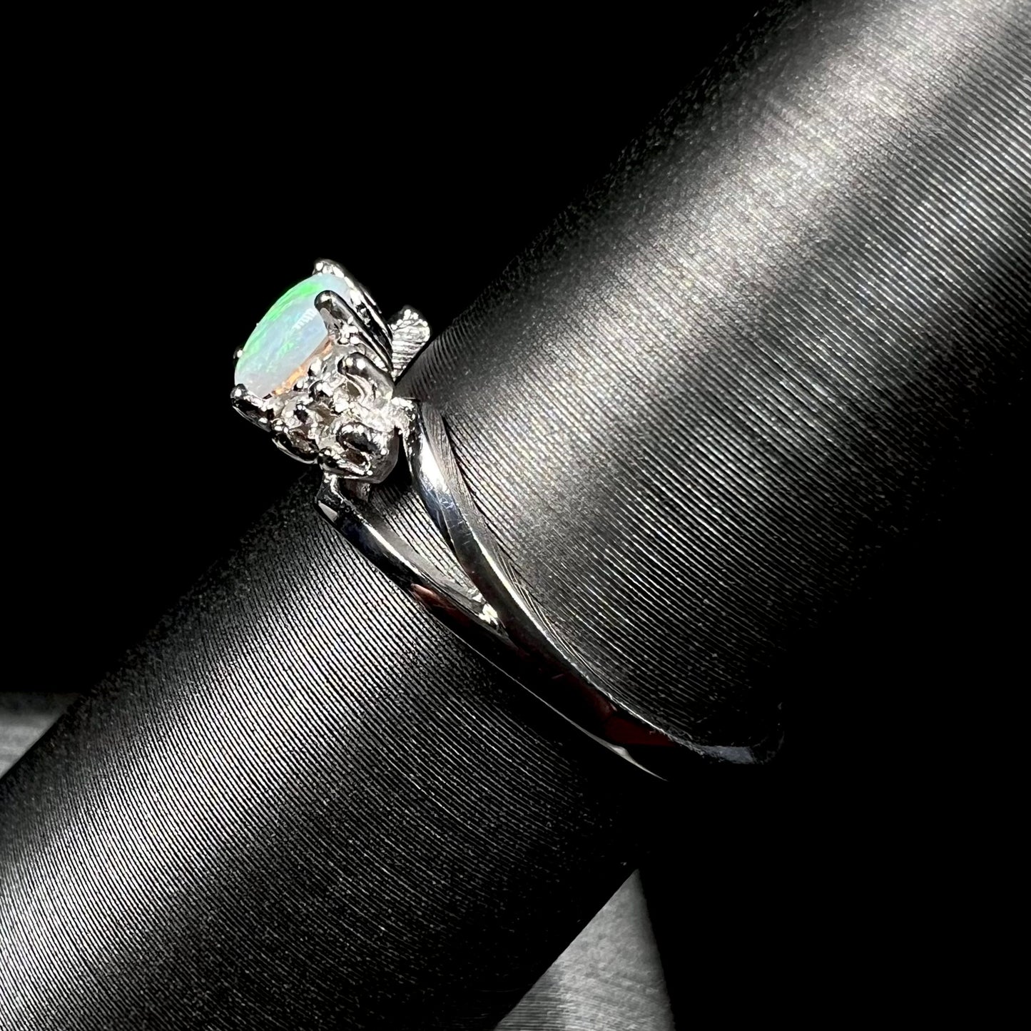 A ladies' white gold opal ring mounted with round diamond accents.