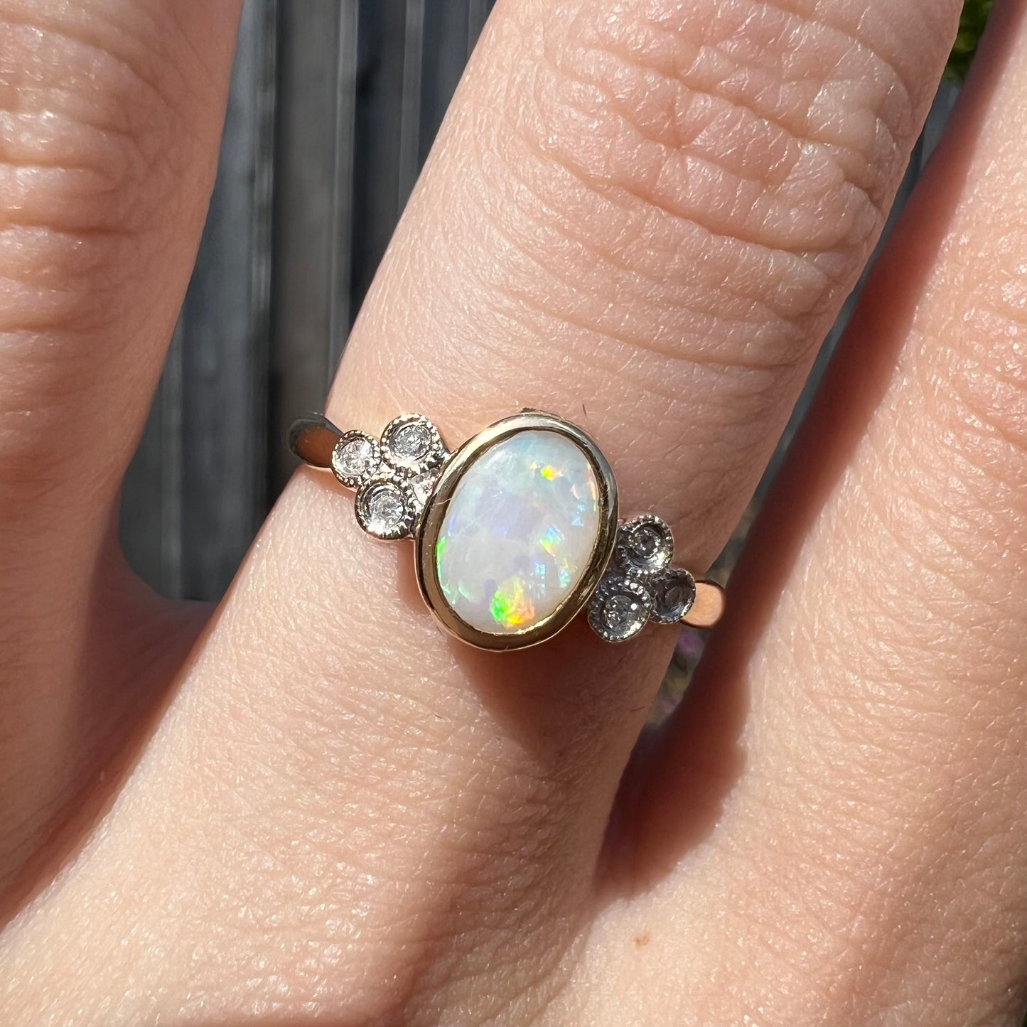 A ladies' yellow gold opal ring.  Three diamonds are set on each side of the opal.  Two rubies are set under the opal.