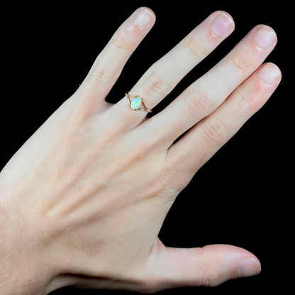 A ladies' simple opal solitaire ring.  The ring is yellow gold with a split shank.