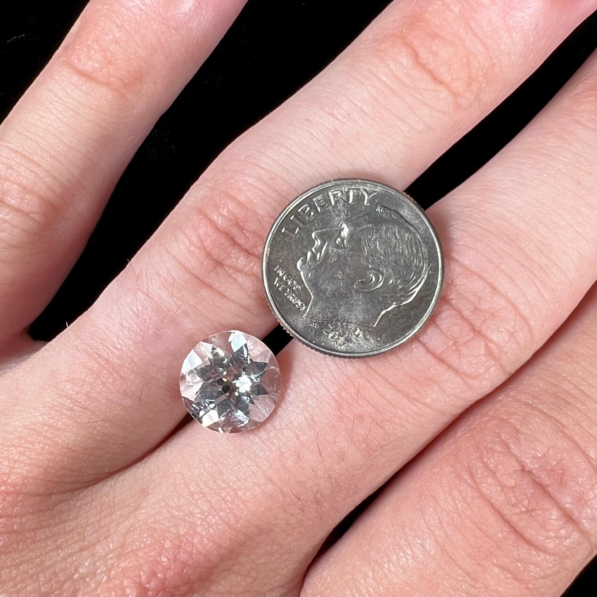 A loose, round checkerboard cut white topaz gemstone.