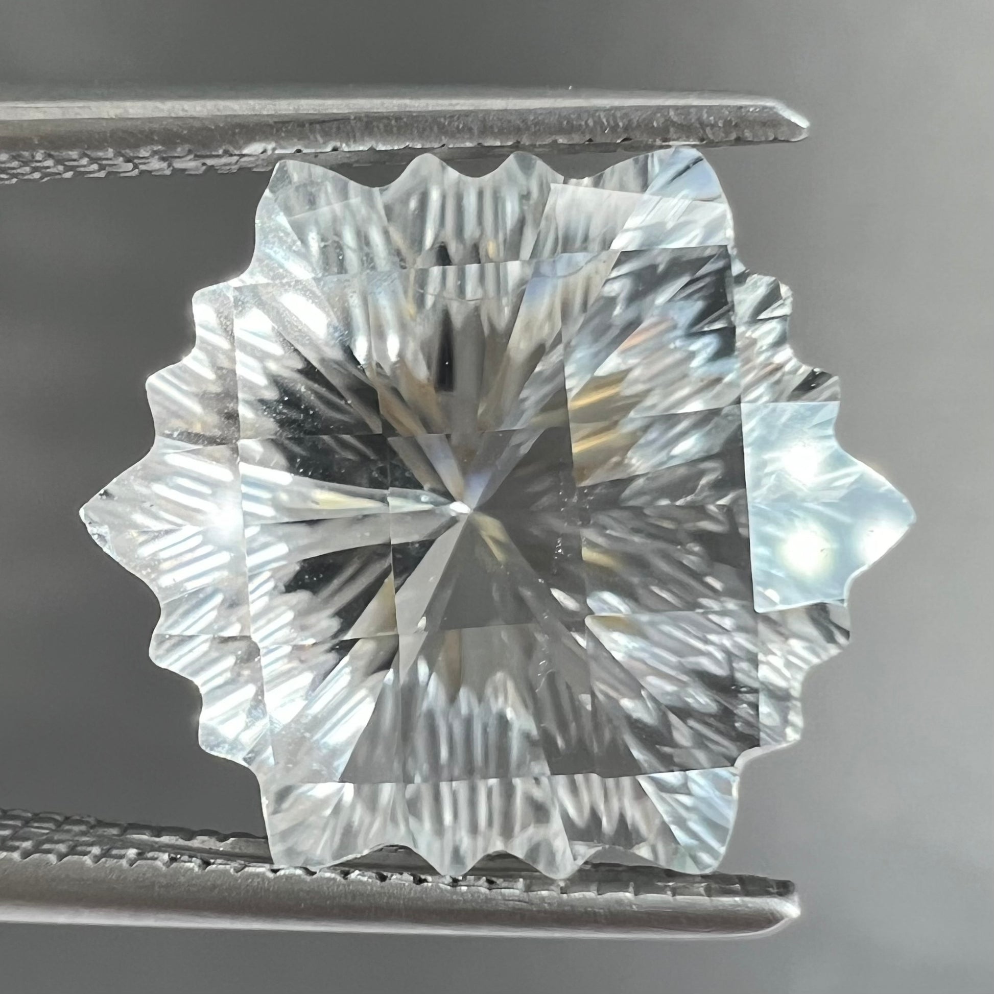 A fantasy snowflake cut white topaz gemstone.