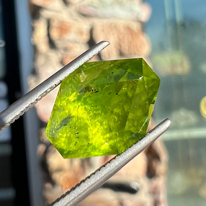 A loose, modified octagon peridot stone.  The stone is a yellow green color.