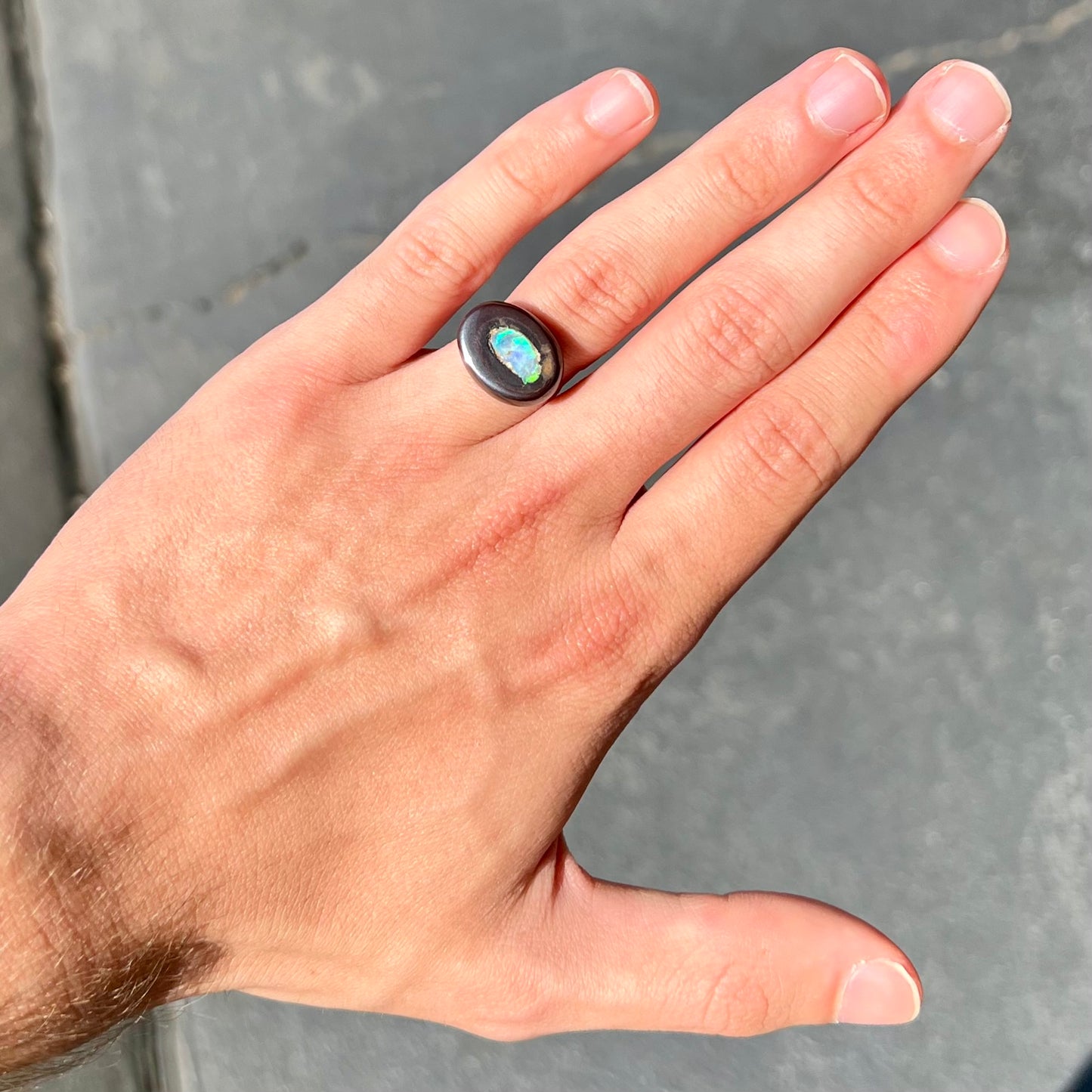 A polished Yowah nut opal stone.  The opal shines blue and green colors.