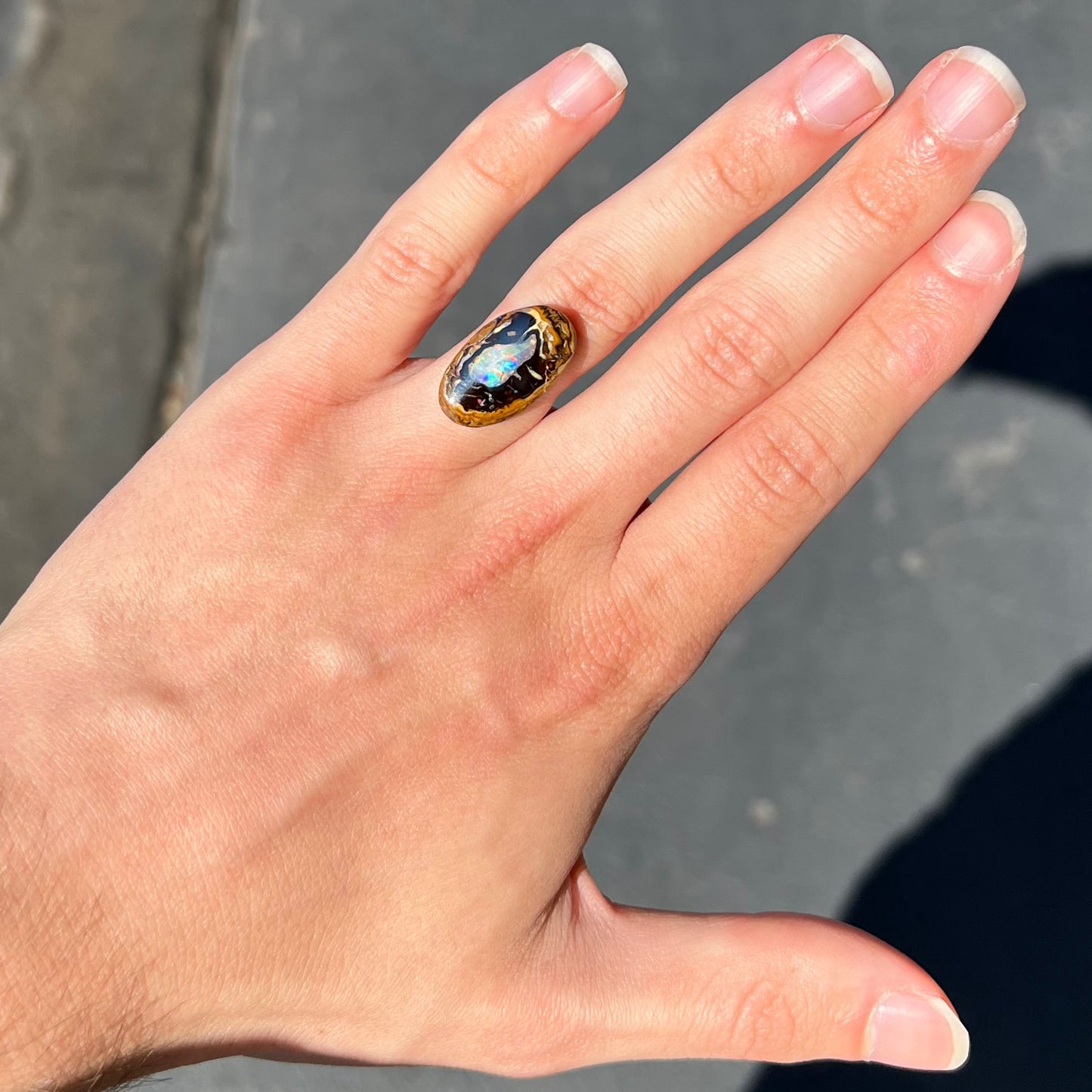 A polished Yowah nut boulder opal from Yowah, Australia.  The piece is ironstone with a center of precious opal.